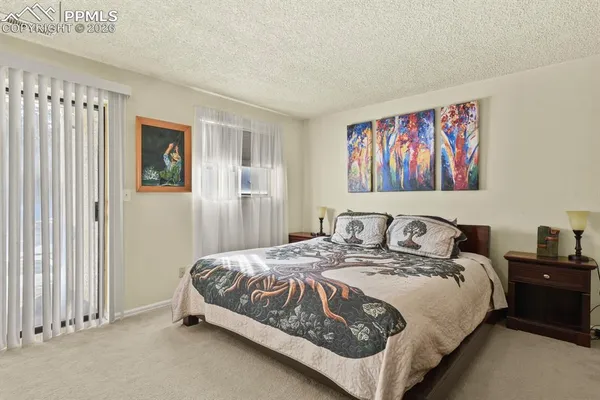 a bedroom with a bed and a painting on the wall