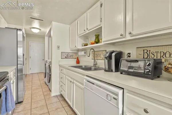 a kitchen with stainless steel appliances granite countertop a sink a stove and cabinets