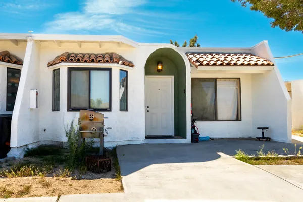 a yellow house sitting in middle of the middle of a yard