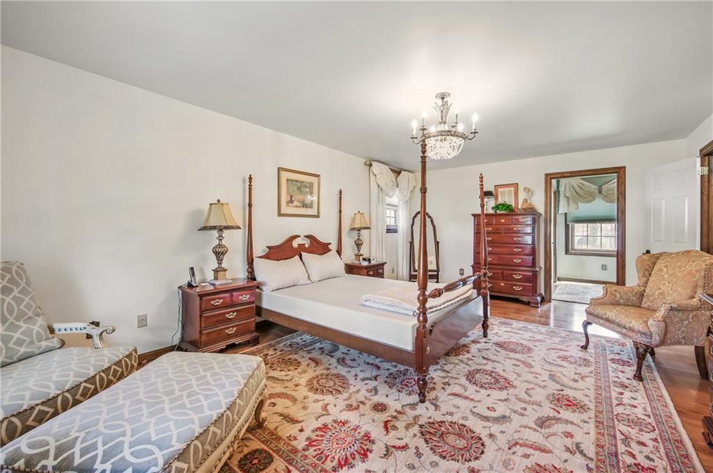 689 Tanglewood Road Hermitage, PA 16148 - Photo 22 of 42 a bedroom with a bed a chandelier and dresser