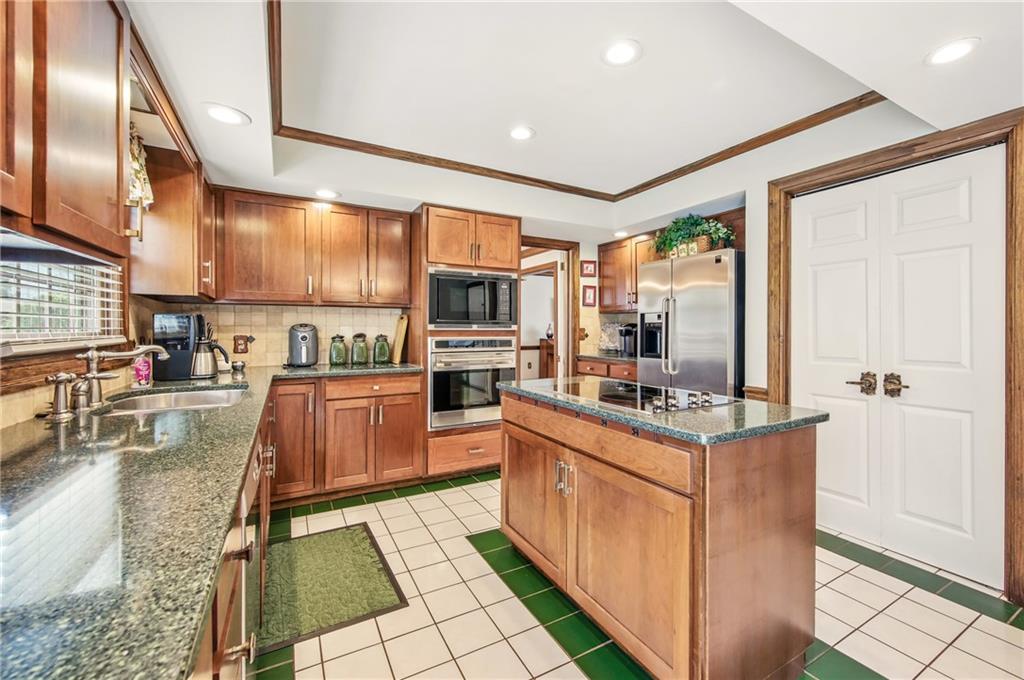 689 Tanglewood Road Hermitage, PA 16148 - Photo 7 of 42 a kitchen with stainless steel appliances kitchen island granite countertop a stove refrigerator and cabinets