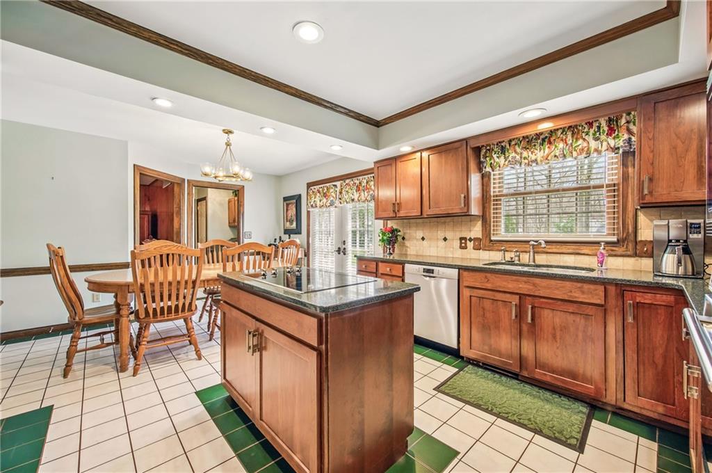 689 Tanglewood Road Hermitage, PA 16148 - Photo 9 of 42 a kitchen with stainless steel appliances granite countertop sink stove top oven table and chairs
