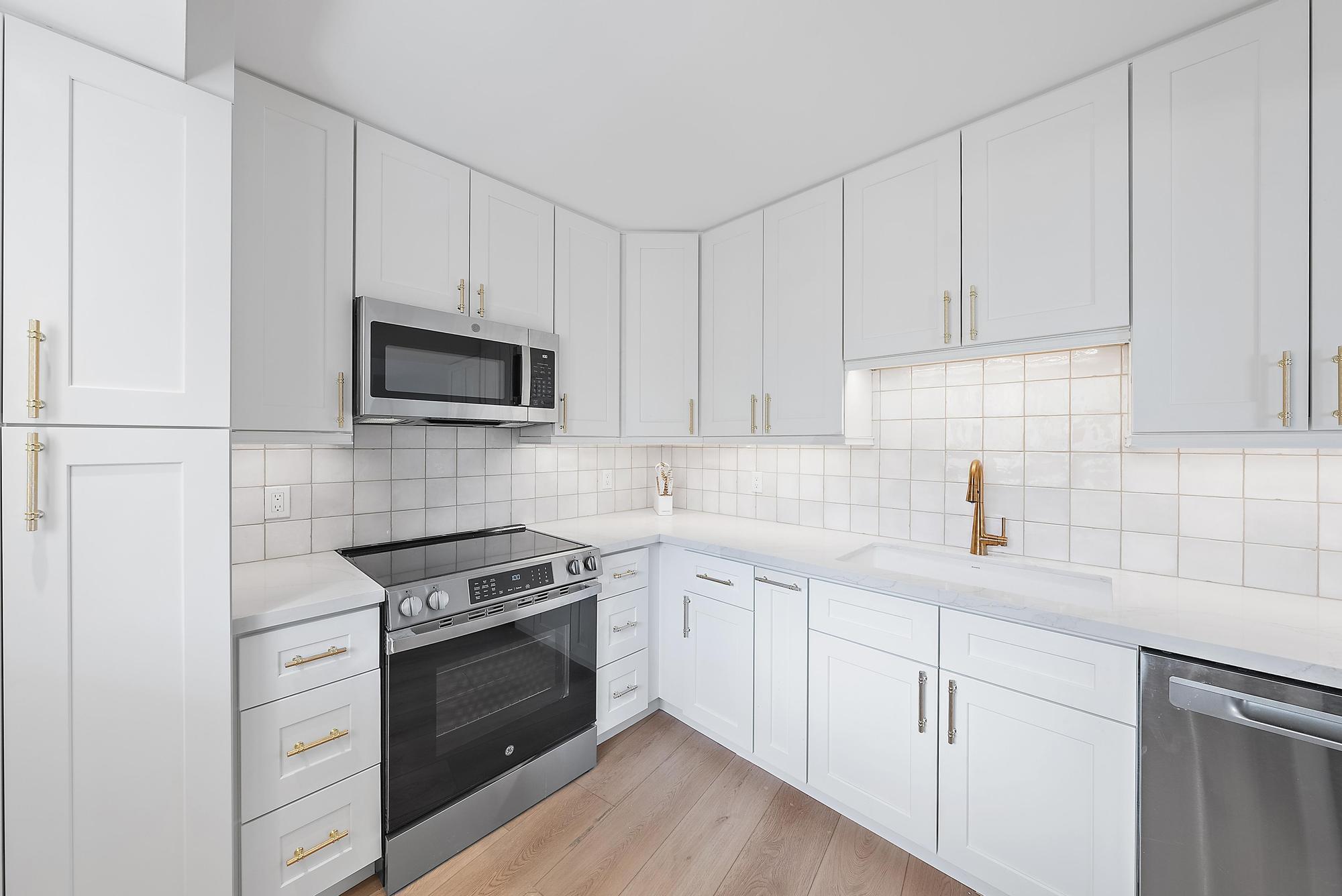 300 Ocean Trail Way, Unit 1202 Jupiter, FL 33477 - Photo 11 of 23 a kitchen with white cabinets and stainless steel appliances