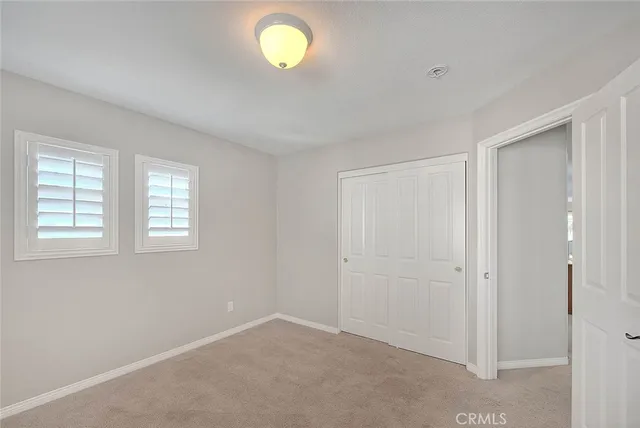 an empty room with chandelier and windows