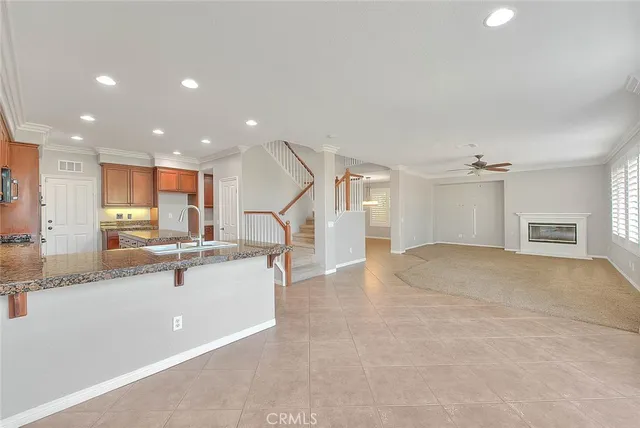 a view of a hallway to an empty room with wooden floor and a window