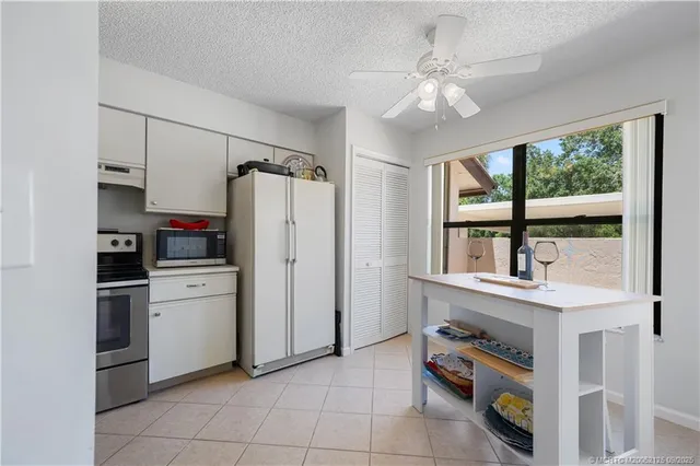 a kitchen with a refrigerator a stove top oven a sink and a window