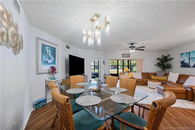 a view of a dining room with furniture a chandelier and wooden floor