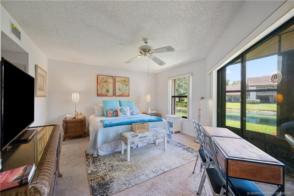 Undisclosed Address Stuart, FL 34997 - Photo 22 of 51 a living room with furniture a flat screen tv and a floor to ceiling window