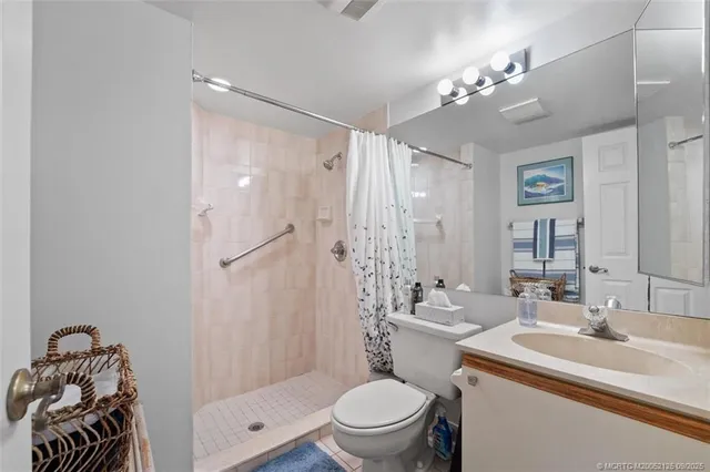 a bathroom with a sink a toilet a mirror a vanity and shower
