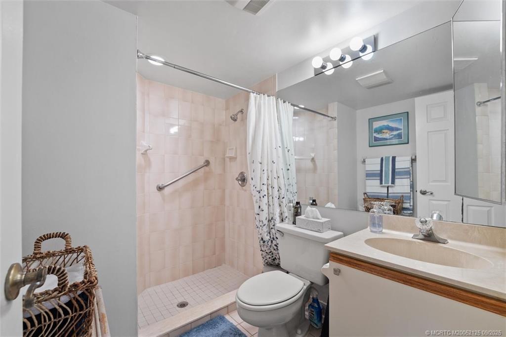 Undisclosed Address Stuart, FL 34997 - Photo 27 of 51 a bathroom with a sink a toilet a mirror a vanity and shower