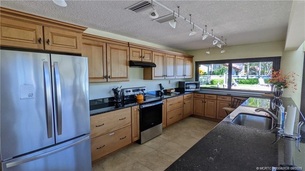 Undisclosed Address Stuart, FL 34997 - Photo 34 of 51 a kitchen with stainless steel appliances granite countertop a refrigerator a sink dishwasher a stove and white countertops with wooden floor