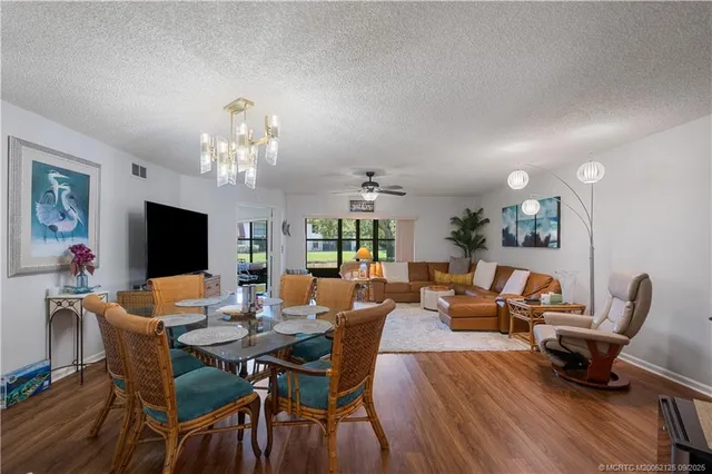 a view of a dining room with furniture wooden floor and chandelier