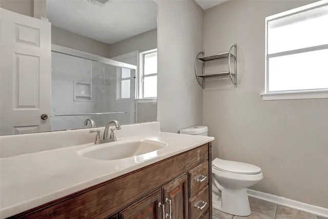 a bathroom with a sink a toilet and a mirror