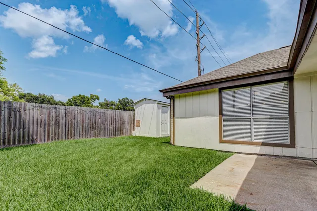 a front view of house with backyard and wooden fence