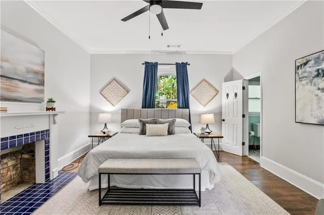 a bedroom with a bed a ceiling fan and a fireplace