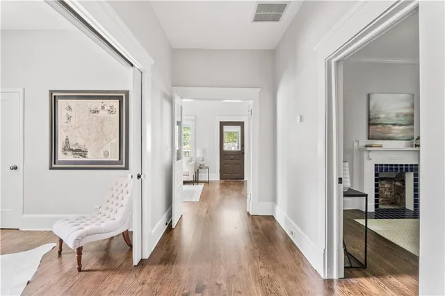 a view of a hallway with wooden floor and cabinet