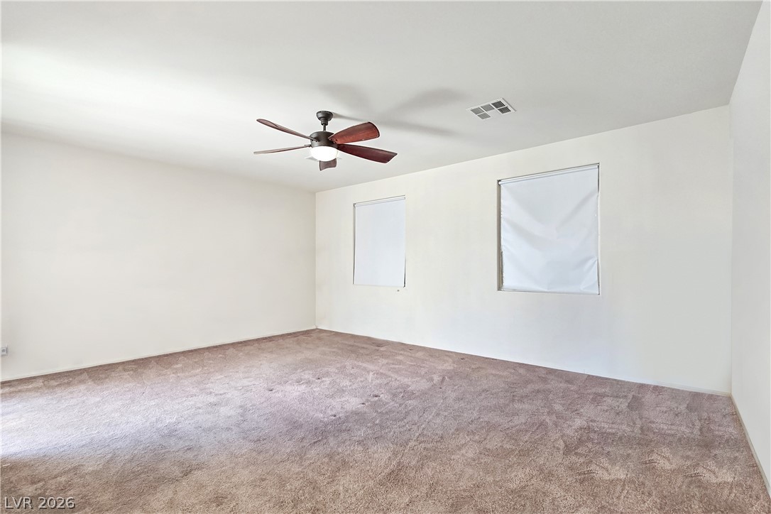2485 Morrow Ridge Place Laughlin, NV 89029 - Photo 21 of 40 A spacious room offers ample natural light and comfortable carpeting, perfect for a peaceful retreat.
