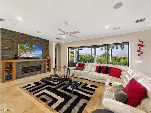 a living room with furniture a flat screen tv and a floor to ceiling window