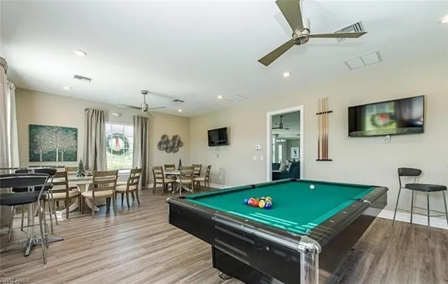 a room with pool table and windows
