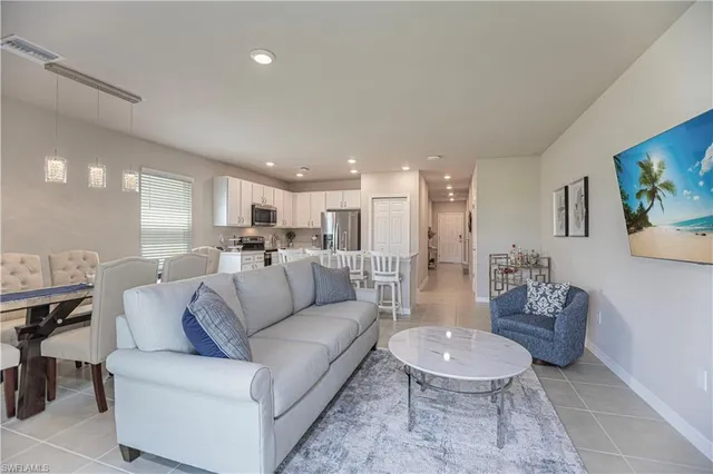 a living room with furniture and a dining table with kitchen view