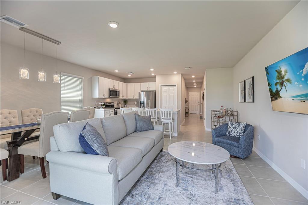 15172 Wildflower Circle Naples, FL 34119 - Photo 2 of 16 a living room with furniture and a dining table with kitchen view