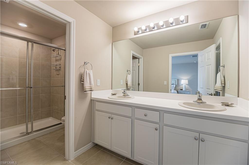 15172 Wildflower Circle Naples, FL 34119 - Photo 6 of 16 a bathroom with a double vanity sink mirror and double