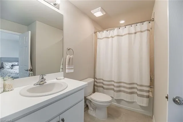 a bathroom with a sink a toilet and shower curtain