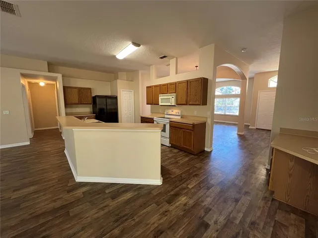 a view of kitchen and hall with wooden floor