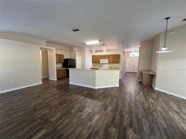 a kitchen with wooden floors and stainless steel appliances
