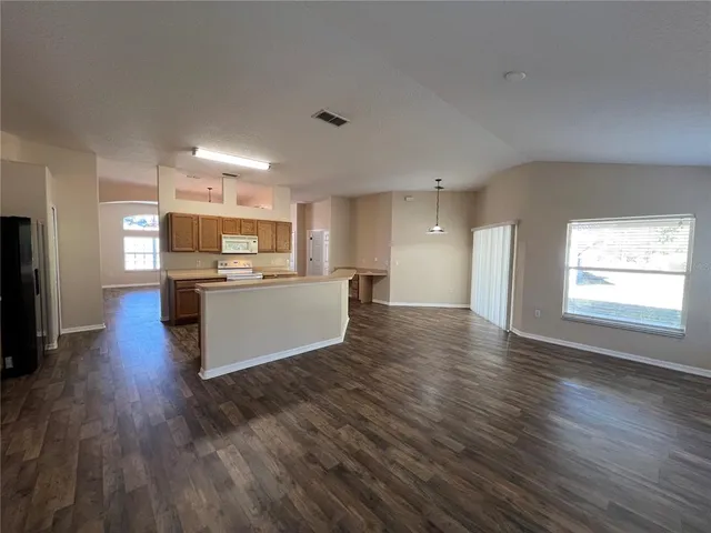 a large kitchen with stainless steel appliances granite countertop a lot of counter space and a sink