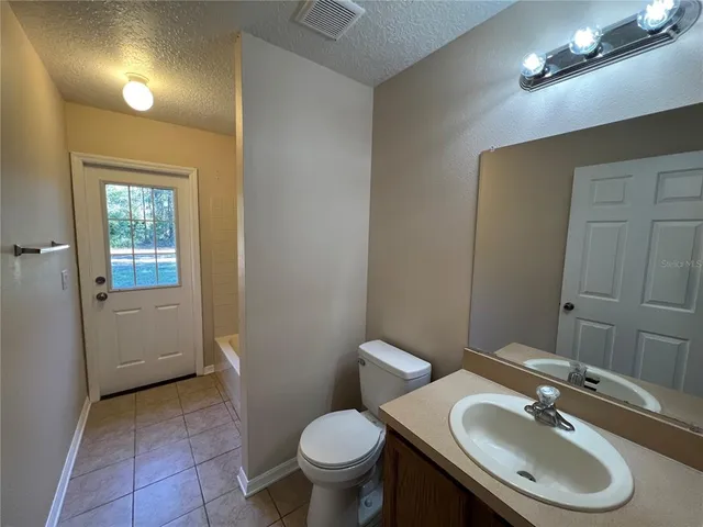 a bathroom with a sink a toilet and mirror