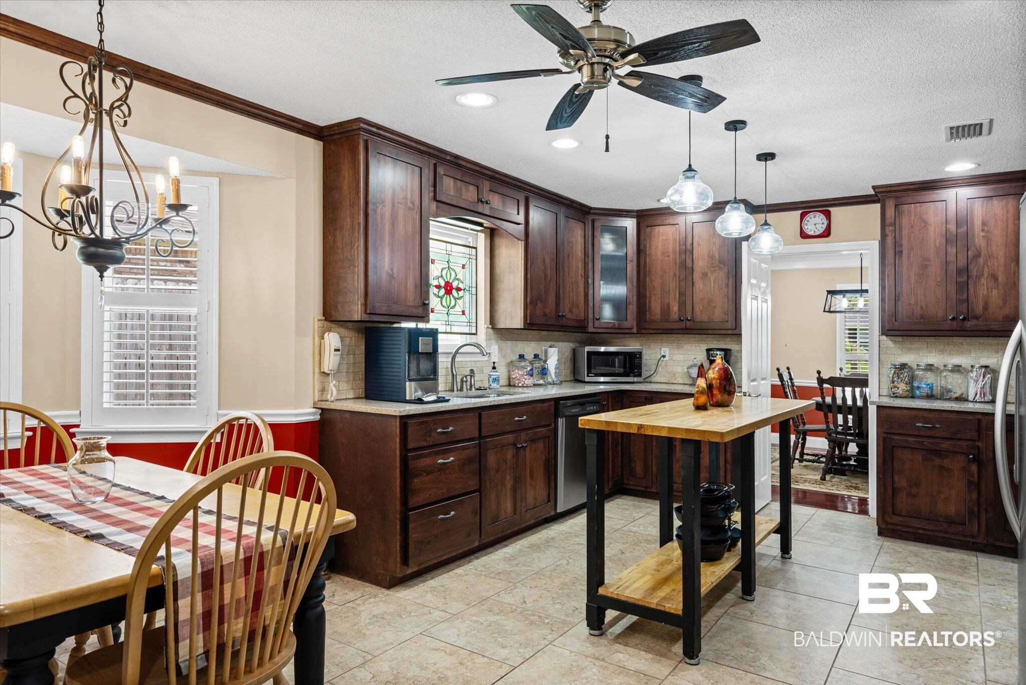 7410 Smithfield Road East Mobile, AL 36695 - Photo 8 of 24 Kitchen featuring extensive dark wood cabinetry, tile flooring, pendant lighting, a ceiling fan, and a stained glass window accent