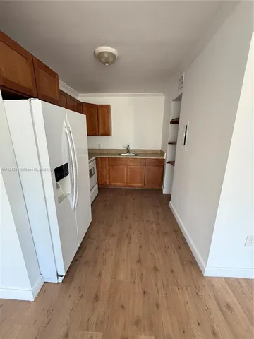 a view of a kitchen with wooden floor and electronic appliances