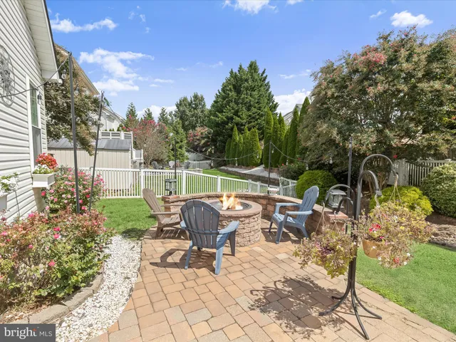 a view of a chair and table in backyard of the house