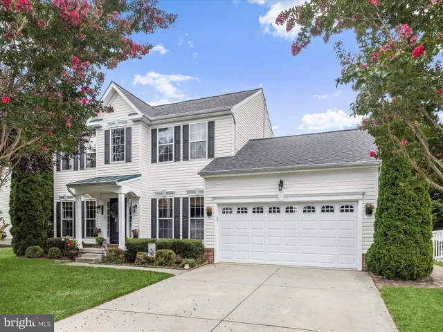 a view of a white house with a yard and plants