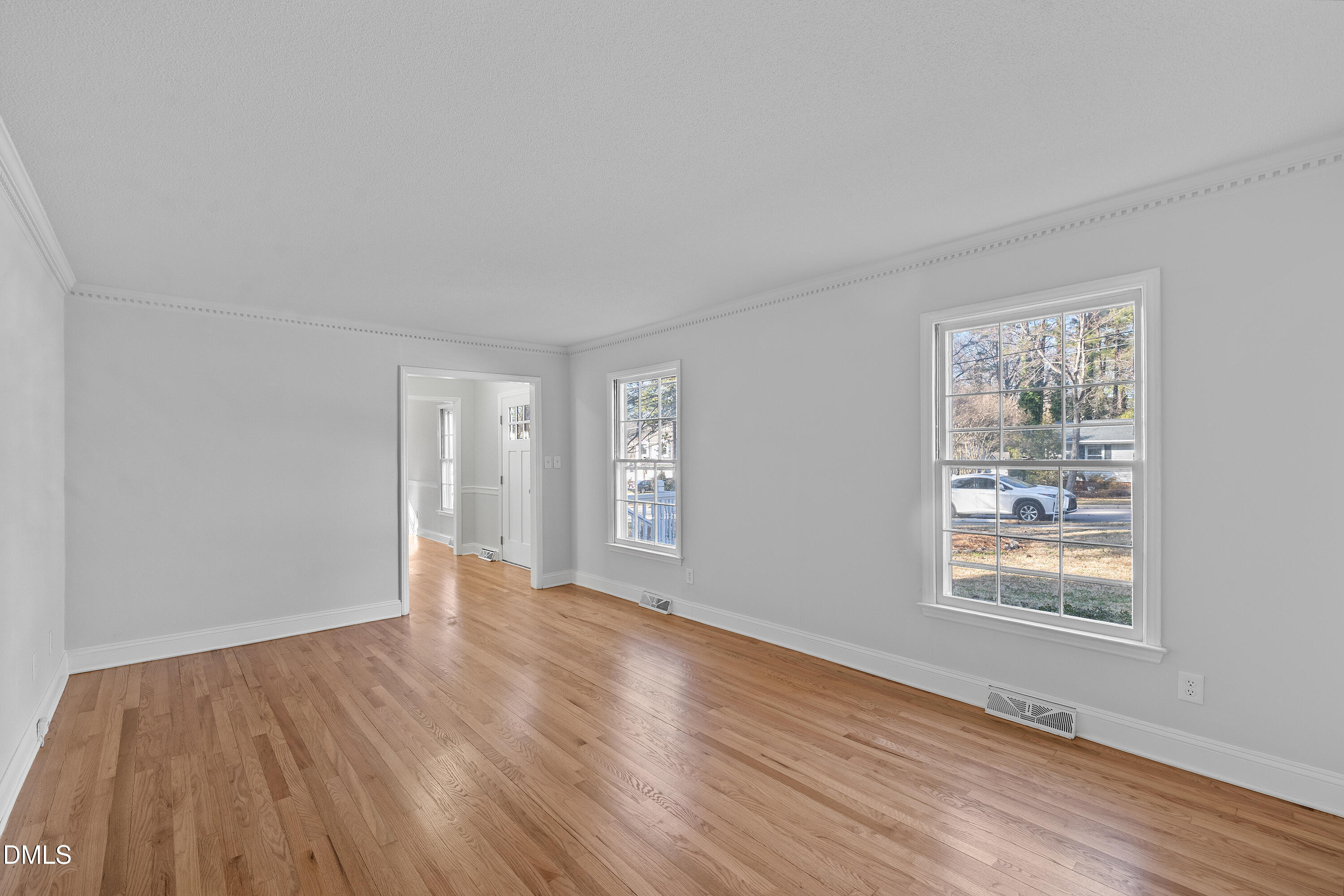 4601 Pemberton Drive Raleigh, NC 27609 - Photo 12 of 44 a view of an empty room with wooden floor and a window