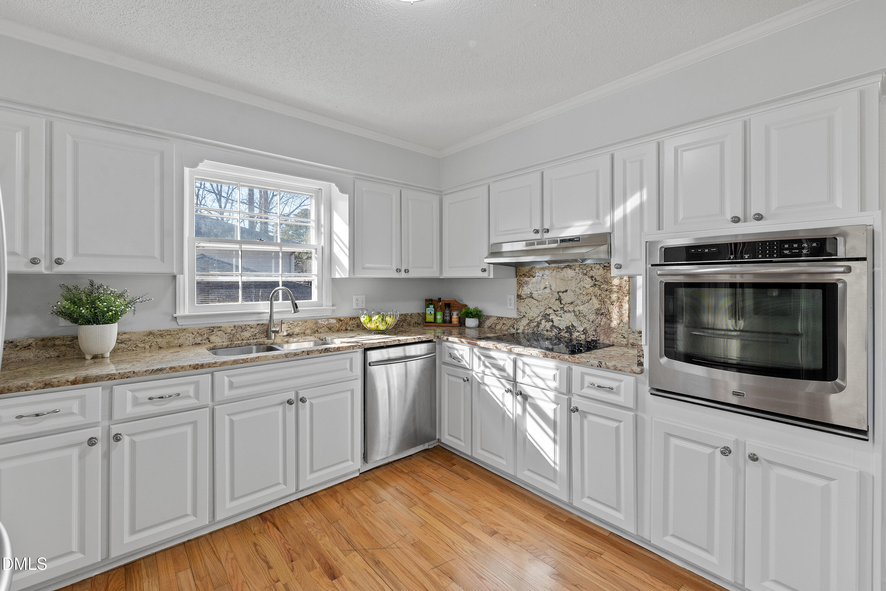 4601 Pemberton Drive Raleigh, NC 27609 - Photo 23 of 44 a kitchen with granite countertop white cabinets stainless steel appliances a sink and a window