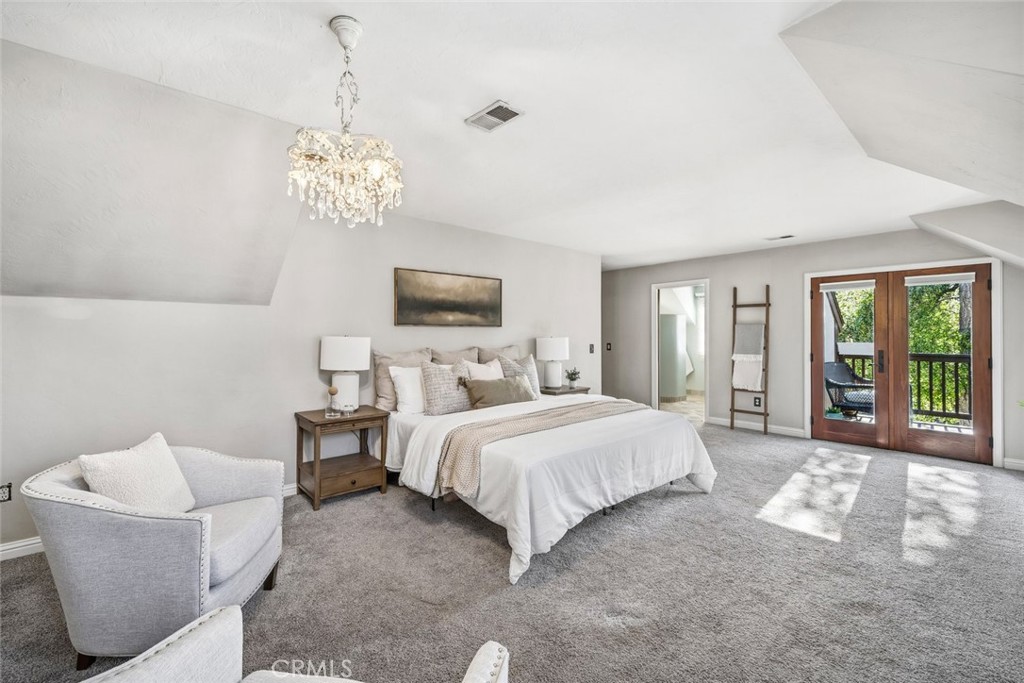 12250 San Antonio Road Atascadero, CA 93422 - Photo 11 of 46 a spacious bedroom with a bed and a chandelier