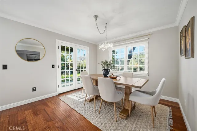 a dining room with furniture a chandelier and wooden floor