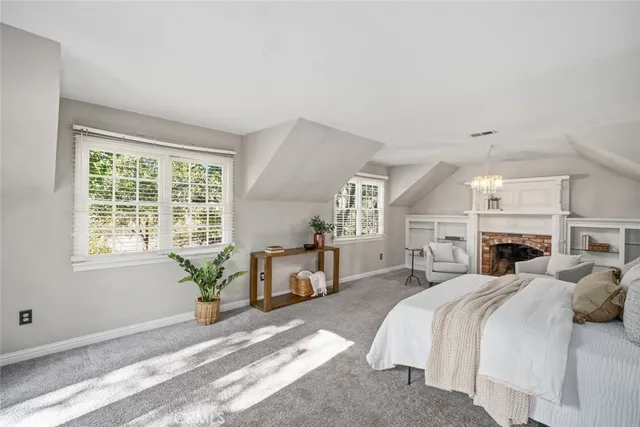 a spacious bedroom with a bed a table and chair