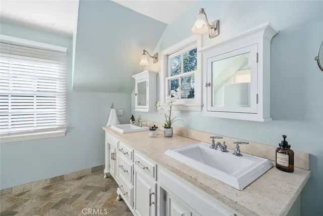 a bathroom with double vanity and a window