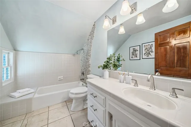 a bathroom with a granite countertop sink a toilet a mirror and bathtub