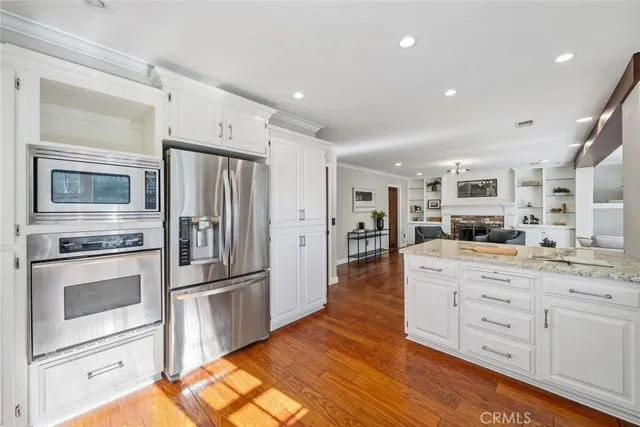 a kitchen with stainless steel appliances kitchen island granite countertop a refrigerator stove and sink