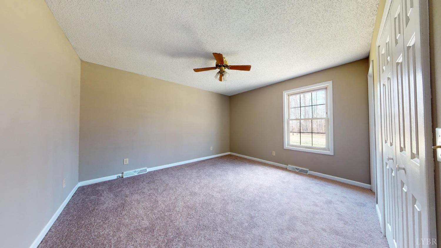 3328 Rocksprings Road Ringgold, VA 24586 - Photo 28 of 39 an empty room with chandelier fan and windows