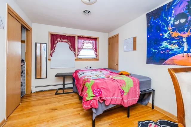 a bedroom with a bed and a painting on the wall