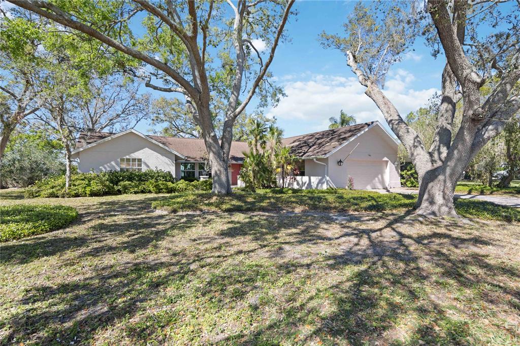 4965 Marsh Field Road Sarasota, FL 34235 - Photo 1 of 1 a view of a yard with plants and a large tree