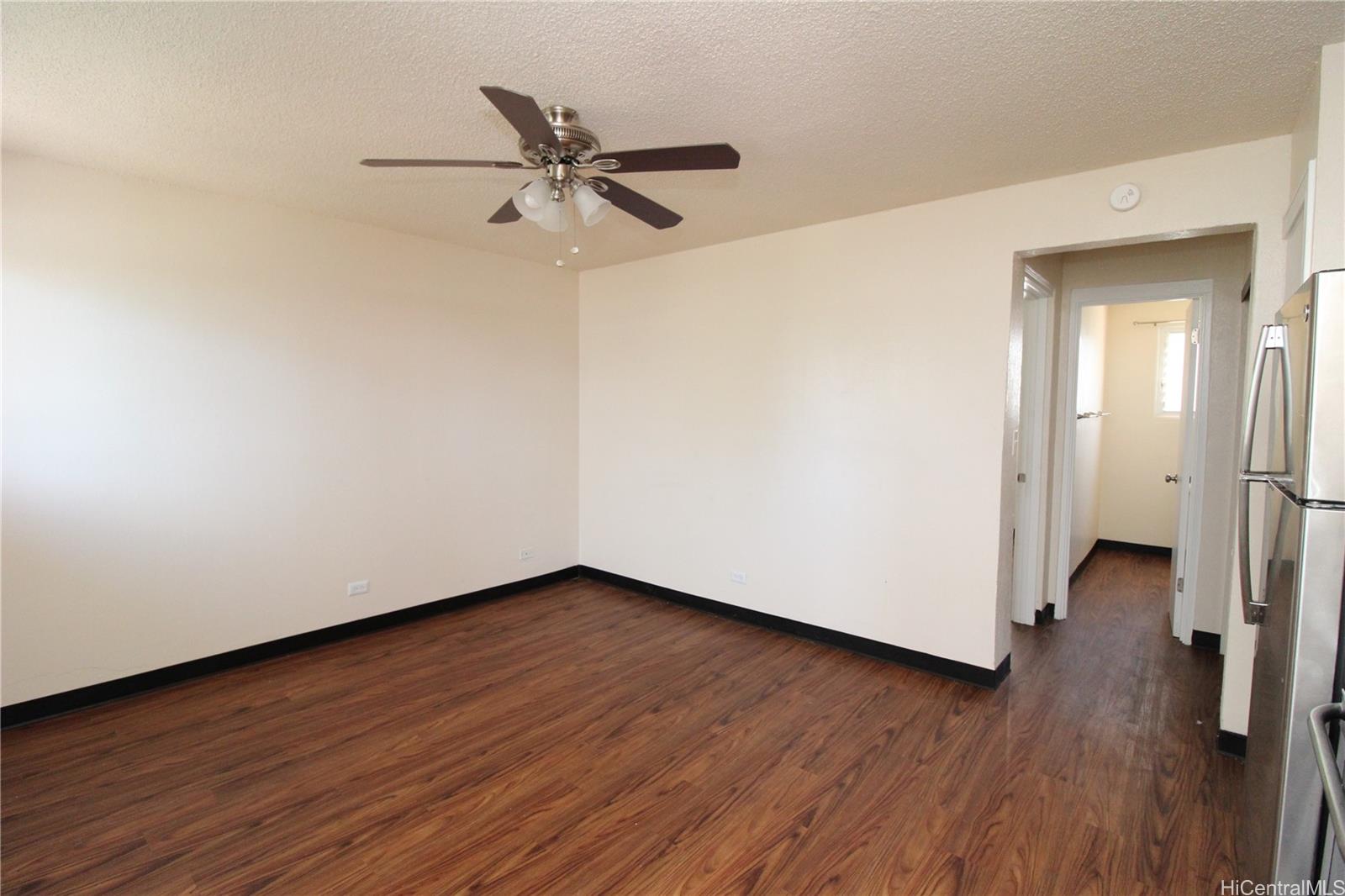 2503 Ala Wai Boulevard, Unit F Honolulu, HI 96815 - Photo 6 of 8 a view of a room with wooden floor closet and a ceiling fan