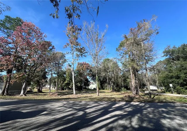 a view of a trees with barn in the background