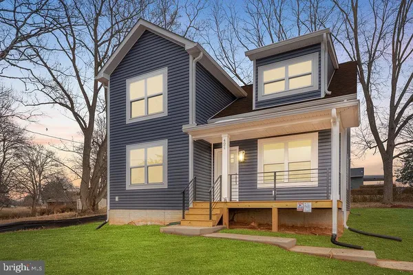a brick house with a large window and potted plant with a small yard