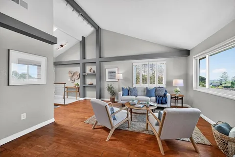 a living room with furniture wooden floor and window